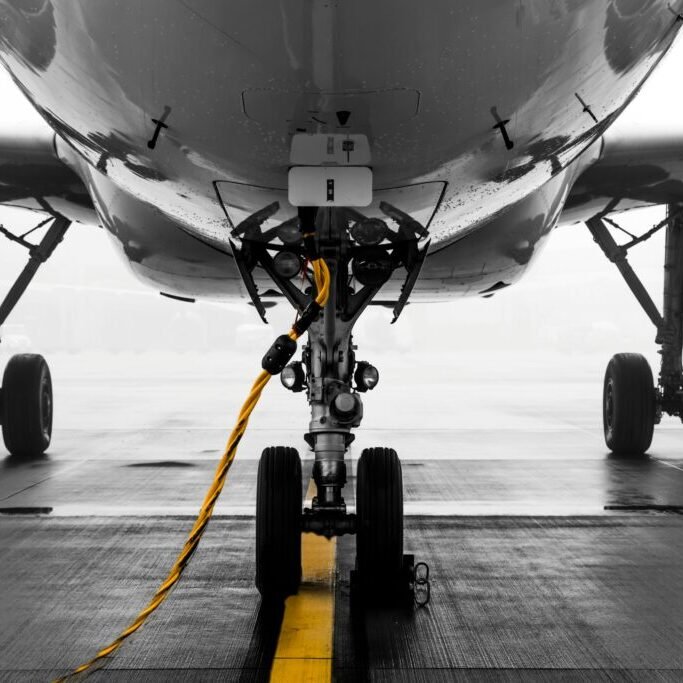 Gray air vehicle with yellow coated cable around docking wheels